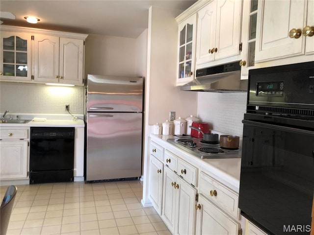 1500 Gravois Rd, High Ridge, MO 63049 - kitchen with black appliances, under cabinet range hood, light countertops, decorative backsplash, and glass insert cabinets