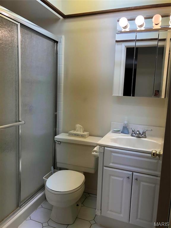1500 Gravois Rd, High Ridge, MO 63049 - bathroom featuring tile patterned flooring, a stall shower, vanity, and toilet