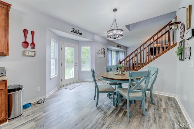 904 Indian Rock Ct, Wentzville, MO 63385 - dining room with baseboards, light wood-type flooring, a chandelier, and stairway