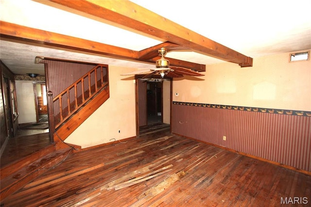 9434 Joan Ct, Bonne Terre, MO 63628 - unfurnished living room featuring wood-type flooring, ceiling fan, wainscoting, beam ceiling, and stairway