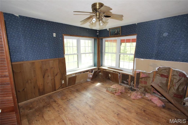 9434 Joan Ct, Bonne Terre, MO 63628 - empty room featuring wainscoting, wallpapered walls, wood finished floors, and a ceiling fan