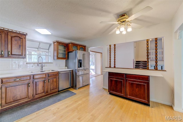 24 Shaw Ct, Cottleville Township, MO 63304 - kitchen with stainless steel appliances, a sink, ceiling fan, light wood-style floors, and light countertops