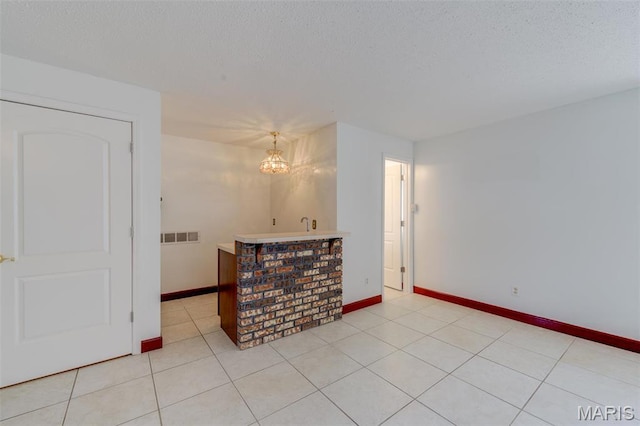 24 Shaw Ct, Cottleville Township, MO 63304 - empty room with a textured ceiling, a chandelier, baseboards, and light tile patterned floors