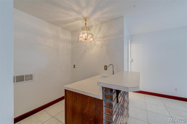 24 Shaw Ct, Cottleville Township, MO 63304 - kitchen with a sink, light countertops, light tile patterned floors, a chandelier, and baseboards