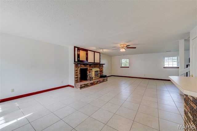 24 Shaw Ct, Cottleville Township, MO 63304 - unfurnished living room with a fireplace, ceiling fan, light tile patterned flooring, a textured ceiling, and baseboards