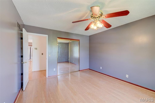 24 Shaw Ct, Cottleville Township, MO 63304 - unfurnished bedroom with light wood-style floors, a closet, a ceiling fan, baseboards, and a textured ceiling
