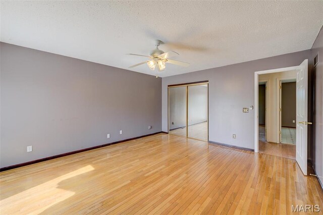 24 Shaw Ct, Cottleville Township, MO 63304 - unfurnished bedroom with light wood-style floors, baseboards, a textured ceiling, a closet, and a ceiling fan