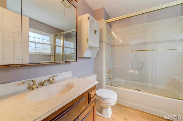 24 Shaw Ct, Cottleville Township, MO 63304 - full bath featuring wood finished floors, toilet, vanity, bath / shower combo with glass door, and a textured ceiling