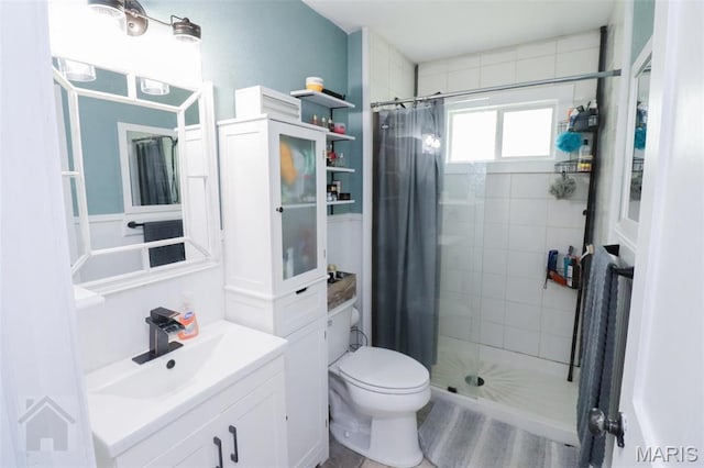 bathroom featuring a shower stall, toilet, and vanity