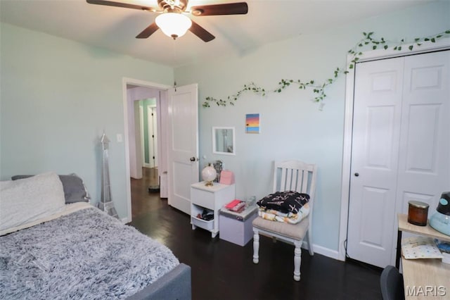 bedroom featuring dark wood-type flooring, baseboards, a closet, and ceiling fan
