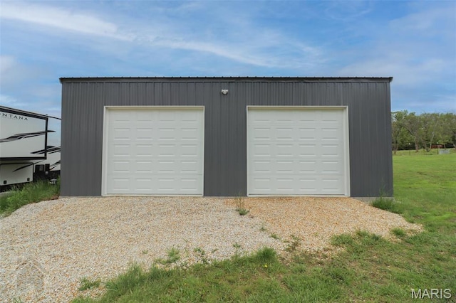 detached garage featuring gravel driveway