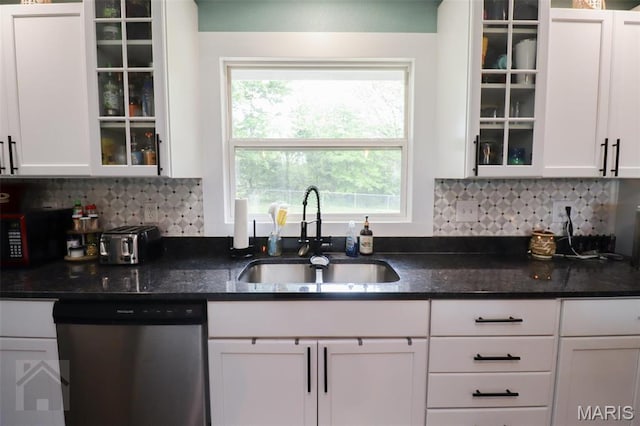 kitchen with dishwasher, a sink, white cabinets, and decorative backsplash