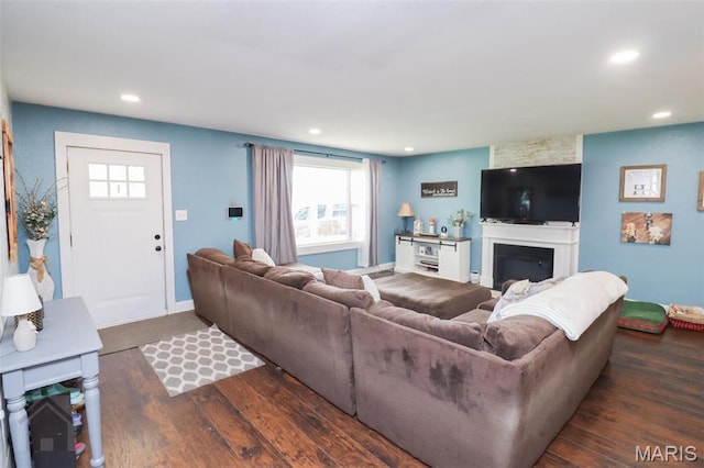 living room with wood finished floors, recessed lighting, a glass covered fireplace, and baseboards