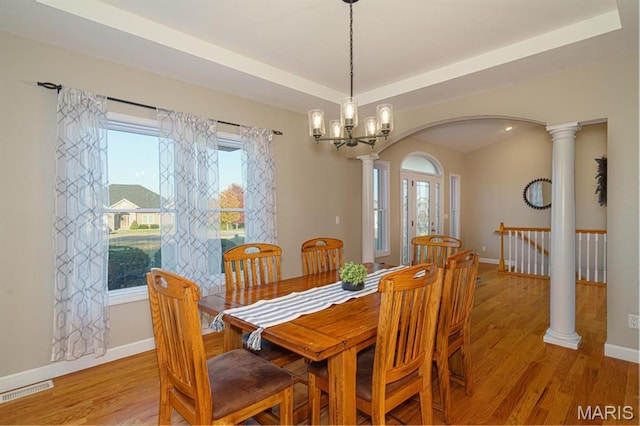 10365 Justin Cir, Rolla, MO 65401 - dining room featuring arched walkways, light wood-type flooring, baseboards, ornate columns, and a chandelier