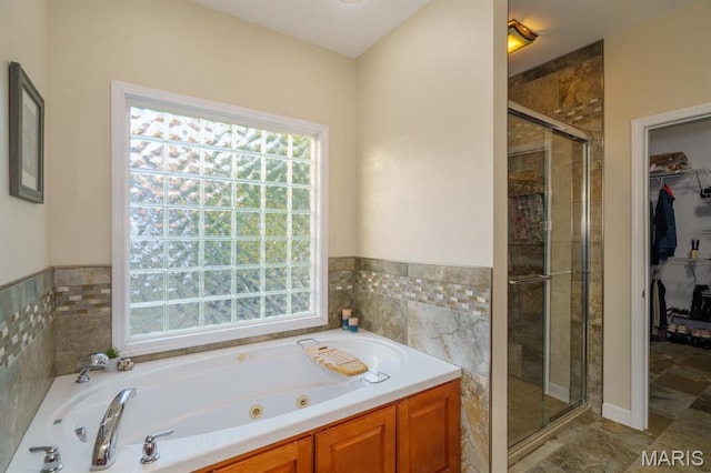 10365 Justin Cir, Rolla, MO 65401 - bathroom with plenty of natural light, a stall shower, a tub with jets, a walk in closet, and tile walls