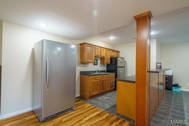10365 Justin Cir, Rolla, MO 65401 - kitchen featuring freestanding refrigerator, dark wood-style flooring, a sink, brown cabinetry, and recessed lighting