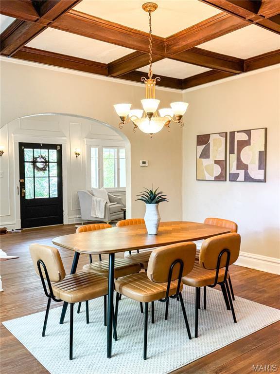 24 S Barat Ave, Saint Louis, MO 63135 - dining area with arched walkways, coffered ceiling, a chandelier, baseboards, and beamed ceiling