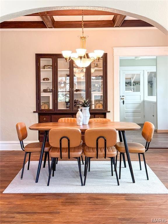 24 S Barat Ave, Saint Louis, MO 63135 - dining space with arched walkways, coffered ceiling, a chandelier, beamed ceiling, and baseboards