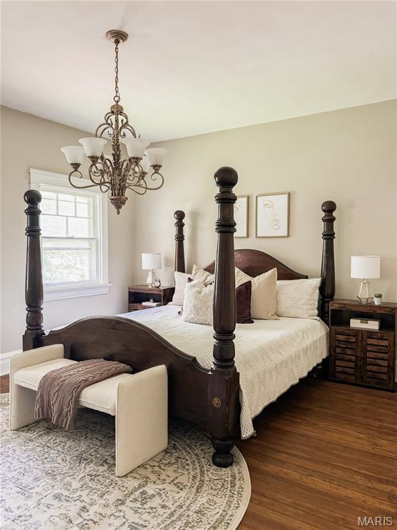 24 S Barat Ave, Saint Louis, MO 63135 - bedroom with dark wood-style floors and a chandelier