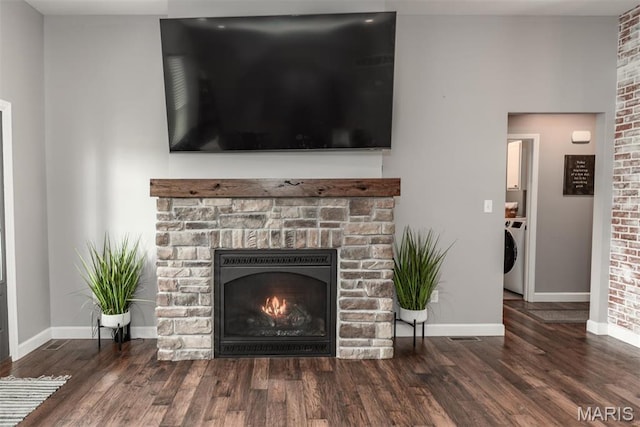 5814 Calvey Creek Rd, Robertsville, MO 63072 - detailed view of washer / dryer, a warm lit fireplace, baseboards, and wood finished floors