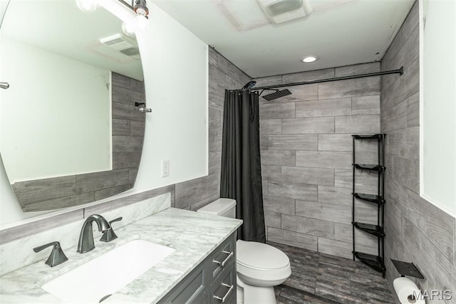 5814 Calvey Creek Rd, Robertsville, MO 63072 - full bathroom featuring toilet, vanity, tile walls, a tile shower, and recessed lighting