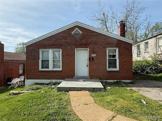 820 Elias Ave, Saint Louis, MO 63147 - bungalow-style home with brick siding, a chimney, and a front lawn