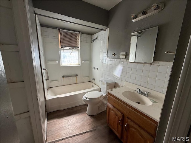 820 Elias Ave, Saint Louis, MO 63147 - bathroom featuring toilet, vanity,  shower combination, wood finished floors, and tile walls