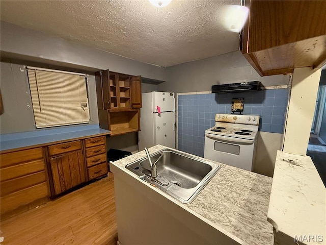820 Elias Ave, Saint Louis, MO 63147 - kitchen with white appliances, brown cabinetry, a sink, light wood finished floors, and a textured ceiling