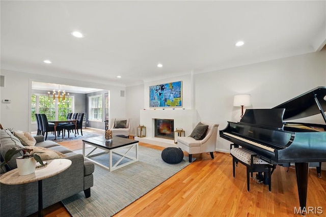 24 Rio Vista Dr, Saint Louis, MO 63124 - living area with light wood-type flooring, a chandelier, recessed lighting, baseboards, and a glass covered fireplace
