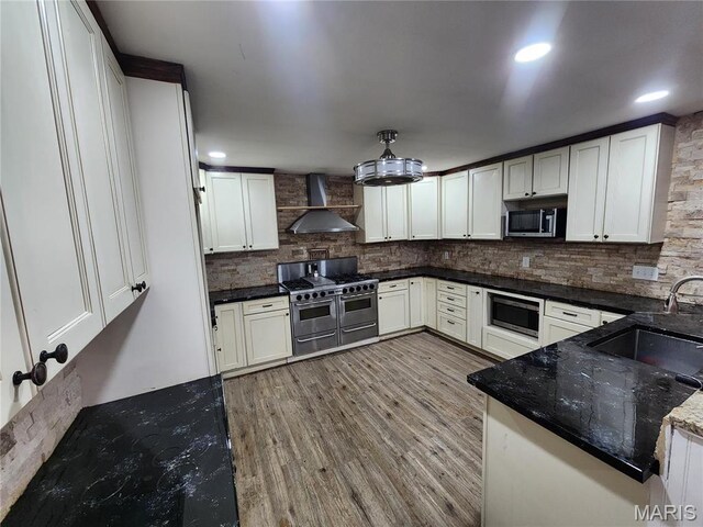 91 N Chantilly Rd, Winfield, MO 63389 - kitchen with wall chimney exhaust hood, stainless steel appliances, a sink, tasteful backsplash, and light wood finished floors