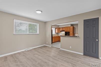 1605 Koch Dr, Florissant, MO 63033 - unfurnished living room featuring baseboards and light wood finished floors