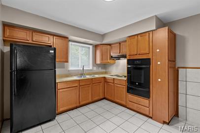 1605 Koch Dr, Florissant, MO 63033 - kitchen featuring black appliances, a warming drawer, a sink, light countertops, and light tile patterned flooring