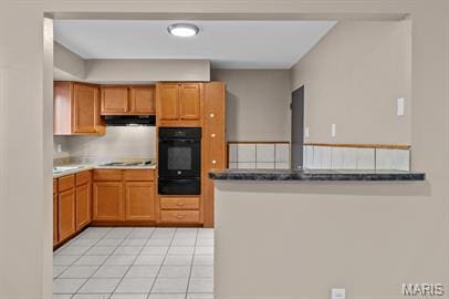 1605 Koch Dr, Florissant, MO 63033 - kitchen with oven, a warming drawer, light tile patterned floors, cooktop, and under cabinet range hood