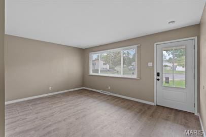 1605 Koch Dr, Florissant, MO 63033 - foyer entrance featuring wood finished floors, plenty of natural light, and baseboards