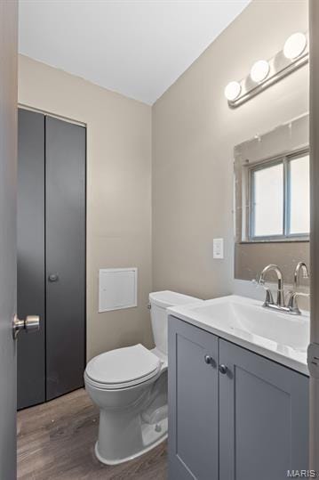1605 Koch Dr, Florissant, MO 63033 - half bath featuring wood finished floors, toilet, and vanity
