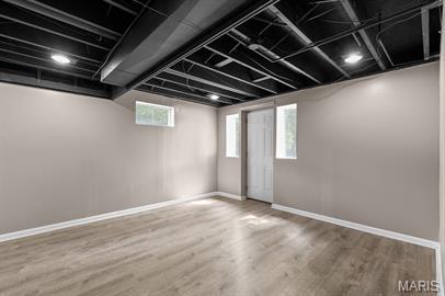 1605 Koch Dr, Florissant, MO 63033 - basement with baseboards, wood finished floors, and plenty of natural light