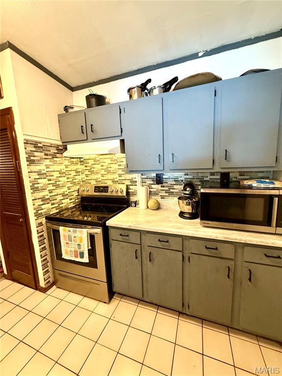 56 Berger Rd, Middletown, MO 63359 - kitchen featuring appliances with stainless steel finishes, range hood, gray cabinetry, backsplash, and ornamental molding