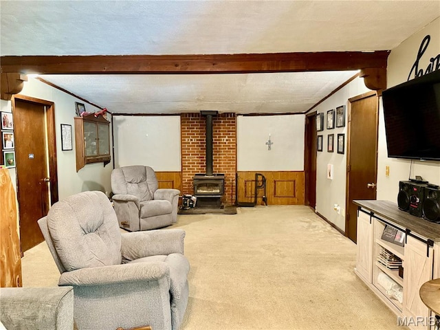 56 Berger Rd, Middletown, MO 63359 - living area featuring a wood stove, beamed ceiling, light colored carpet, and a wainscoted wall