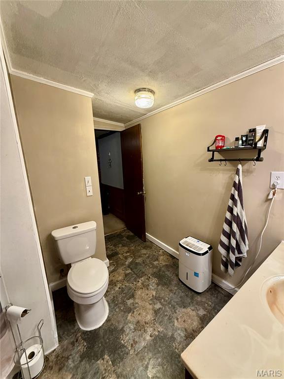 56 Berger Rd, Middletown, MO 63359 - bathroom with a textured ceiling, crown molding, toilet, and baseboards