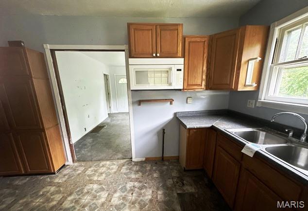 9909 Baltimore St, Belleville, IL 62223 - kitchen featuring white microwave, brown cabinets, and a sink