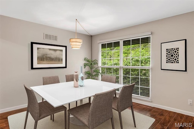 dining room featuring baseboards and dark wood-type flooring