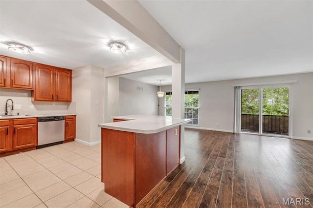 kitchen with dishwasher, light countertops, plenty of natural light, and baseboards