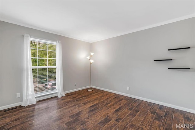 empty room with crown molding, baseboards, and wood finished floors