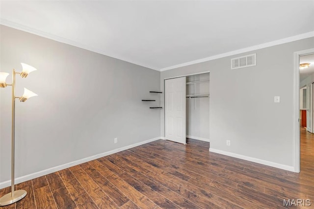 unfurnished bedroom featuring wood finished floors, baseboards, a closet, and ornamental molding