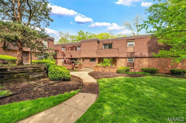 view of front of house with brick siding and a front yard