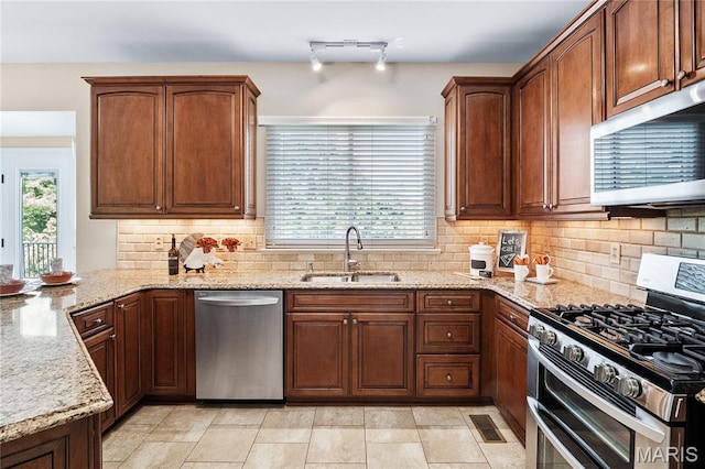 1309 Wellington Valley Ct, Chesterfield, MO 63005 - kitchen with stainless steel appliances, a sink, light stone countertops, tasteful backsplash, and a peninsula