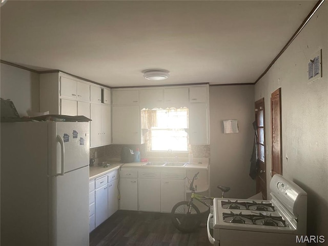 1205 W Mccarty St, Jefferson City, MO 65109 - kitchen with white appliances, a sink, backsplash, white cabinetry, and dark wood-type flooring