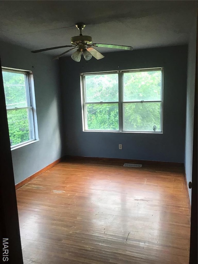 1205 W Mccarty St, Jefferson City, MO 65109 - spare room with wood finished floors, ceiling fan, and baseboards