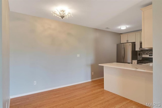 1316 Holgate Dr Unit G5, Ballwin, MO 63021 - kitchen featuring freestanding refrigerator, stove, backsplash, light wood-style flooring, and baseboards