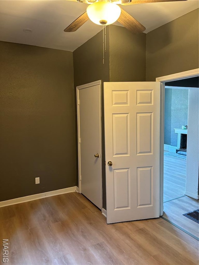 4844 Northland Ave, Saint Louis, MO 63113 - unfurnished bedroom featuring light wood-style flooring, a fireplace, and a ceiling fan
